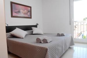 a white bedroom with a bed with towels on it at Apartamento Montroig 1 in Sitges
