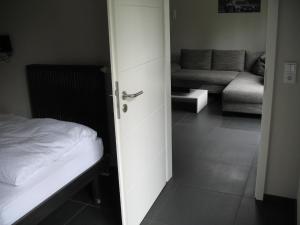 een open deur naar een slaapkamer met een bed en een bank bij RING-RACE-FLATS Appartements in Adenau