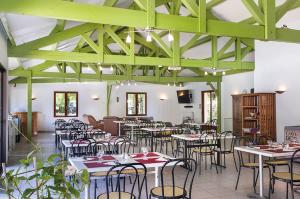 Camping les Borgnes Saint-Sozy في Saint-Sozy: غرفة طعام مع طاولات وكراسي في مبنى