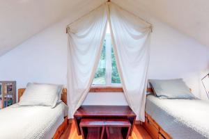 2 camas individuales en una habitación con ventana en Whimsy by the Sea, en Port Orford