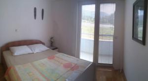 a small bedroom with a bed and a window at Matea Apartments in Ohrid