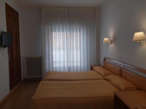 a hotel room with two beds and a window at Hotel Amefa in Salamanca