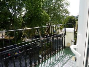 a balcony with an iron railing and a view of a street at The Iona in Torquay