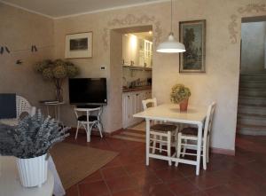 cocina y sala de estar con mesa y TV en Il Borgo Delle Grazie, en Ovada