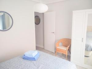 a bedroom with a bed and a mirror and a chair at San Lorenzo House in Gijón