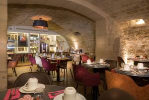 restauracja ze stołami i krzesłami oraz bar w obiekcie Hotel Du Cadran w Paryżu