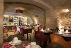 a restaurant with tables and chairs and a bar at Hotel Du Cadran in Paris