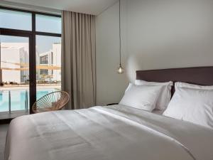 a bedroom with a bed and a view of a pool at Cavo Vezal in Laganas