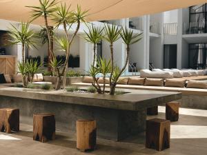 a lobby with palm trees and a table and benches at Cavo Vezal in Laganas