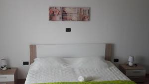 a bedroom with a white bed with two night stands at App. Adriatic Aurora in Umag