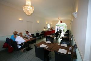 een eetkamer met mensen aan tafel in een restaurant bij Hotel Duinzicht in Scheveningen