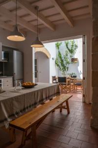 - une cuisine avec une table et un banc dans une pièce dans l'établissement Cal Bisbe, à Ciutadella