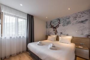 - une chambre avec un lit orné d'une peinture murale sur cerfs dans l'établissement Emerald Stay Apartments Morzine - by EMERALD STAY, à Morzine