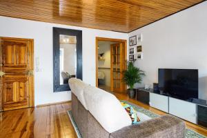 uma sala de estar com um sofá e uma televisão de ecrã plano em Apolónia Train Spot em Lisboa