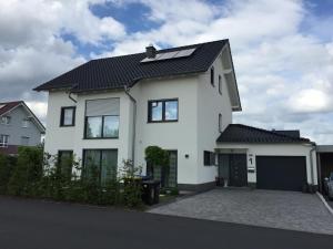ein weißes Haus mit schwarzem Dach in der Unterkunft Ferienwohnung Gentner Fulda in Fulda