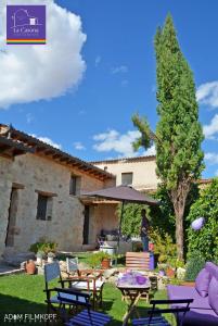 una persona parada en un patio con una sombrilla en La Casona de Castilnovo - Gay Men Only, en Valdesaz