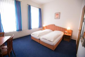 a bedroom with a large bed and a table with a table at Rabes Hotel Kiel in Kiel