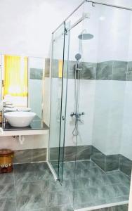 ファンランにあるĐức Chính Hotel - Ninh Chu - Phan Rangのバスルーム(ガラス張りのシャワー、シンク付)