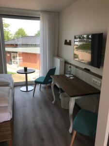 a living room with a desk and a table and chairs at Kanal-Haus "Das Gästehaus direkt am Nord-Ostsee-Kanal" in Osterrönfeld