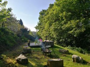 a garden with rocks and a boat on a canal at Roselyn House in Par