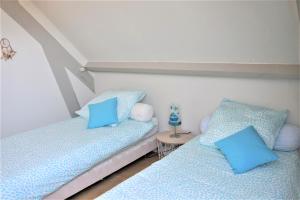 プロムールにあるMaison 7 personnes avec grand jardin - proche plage - ARGANTELの青い枕が備わる客室内のベッド2台