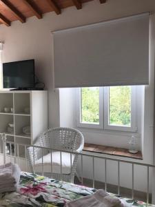 a bedroom with a bed and a chair and a window at Il Casalone in Impruneta