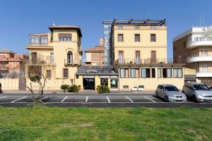 two cars parked in a parking lot in front of a building at Hotel Bellavista in Lido di Ostia