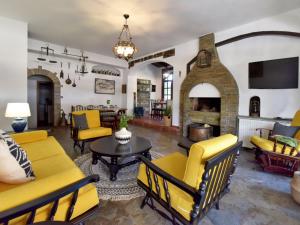 a living room with yellow furniture and a fireplace at Ares Garden House - Nea Moudania Halkidiki in Nea Moudania