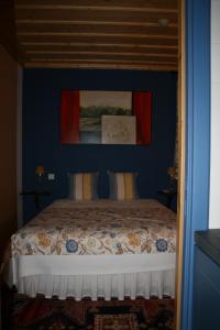1 dormitorio con 1 cama con pared azul en Quinta da Fonte Arcada en Paço de Sousa