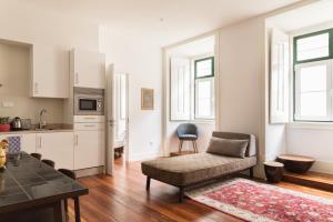a living room with a couch and a kitchen at The Visionaire Apartments in Lisbon