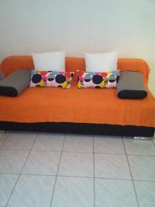 un sofá naranja con almohadas encima en Apartments Jerica, en Bol