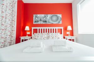 sypialnia z białym łóżkiem i czerwonymi ścianami w obiekcie Colorful and diaphanous- 3Bd 1Bth - Peral w Sewilli
