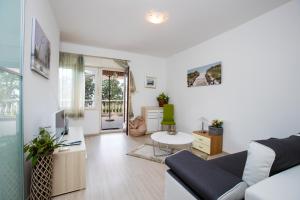 a living room with a couch and a table at Apartments Green Garden in Opatija