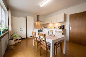 a kitchen with a white table and chairs at Gemütliche Ferienwohnung im Aalbachtal - Uettingen bei Würzburg - Parkplatz und Wallbox in Uettingen
