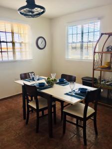 波奎隆的住宿－El Poblado Boquerón Cabo Rojo，餐桌、椅子和墙上的时钟