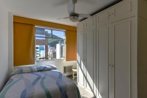 1 dormitorio con cama y ventana en Apartamento Ipanema Posto 9 com suite 2 quadras da praia, en Río de Janeiro