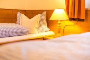 a bedroom with a bed with a lamp and pillows at Schwabenbauernhof-Tradition und Moderne erleben in Ruhpolding
