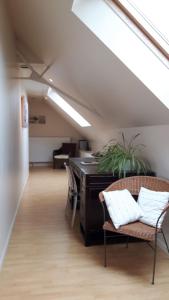an attic room with a desk and chairs and a couch at la noue aubert in Juigné-sur-Loire