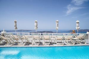 a group of chairs sitting next to a swimming pool at Villa Ilias in Firostefani