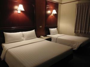 a hotel room with two beds and a phone at MIDO Hotel in Bangkok