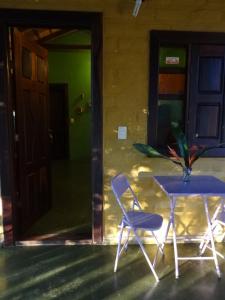 a table and a blue chair in front of a house at Chalé Chapada dos Veadeiros in Cavalcante