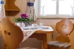 a table with two chairs and a table with flowers on it at Schwabenbauernhof-Tradition und Moderne erleben in Ruhpolding +34 photos