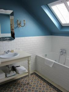 a bathroom with a sink and a bath tub at Villa Adélaïde in Chimay