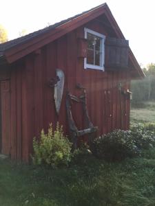 um barracão vermelho com uma porta e uma janela em Björnåsen Bear Hill em Katrineholm