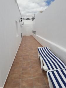 プエルト・デル・カルメンにあるCasa Olivina 2の白と青のストライプのベンチ付きのバルコニーが備わる客室です。