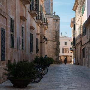 a group of bikes parked on a street next to buildings at Cal Bisbe in Ciutadella