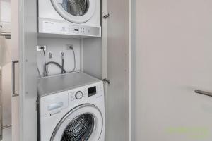 a washing machine and a dryer in a room at QV Stays Spacious City Getaway in Auckland
