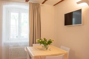uma sala de jantar com uma mesa e uma televisão na parede em Residenza Romantica em Riva del Garda