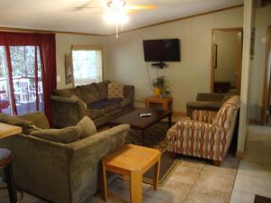 a living room with couches and a flat screen tv at Island Club #53 in Put-in-Bay