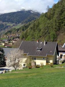 una casa con paneles solares en el lateral de una montaña en Zirnberg Appartements, en Flattach